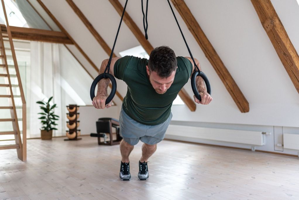 NOHRd Sling being used for a pull up and working chest muscles  