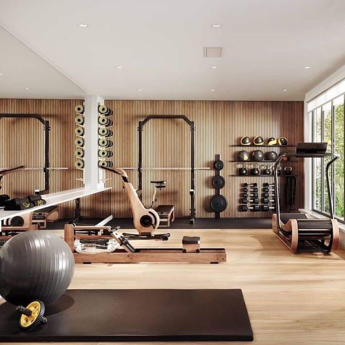 Modern luxury home gym with various exercise equipment against an oak acoustic wall.